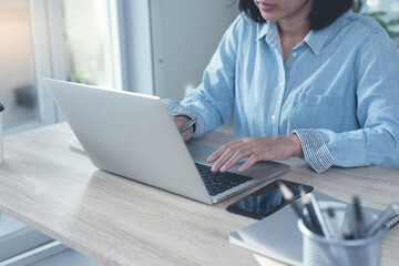 Woman hands typing on laptop computer surfing the internet and online working in office