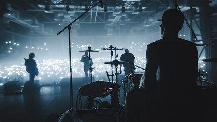 Music band group silhouette perform on a concert stage.  
Silhouette of drummer playing on...