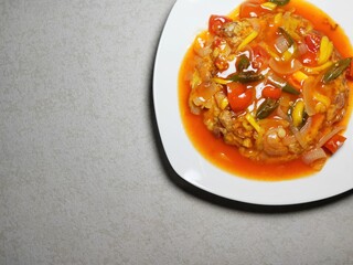 Fu yung hai on white plate, Puyonghai or egg foo young, a famous Chinese-style emelette dish in Indonesia. made from egg, vegetables and sauce