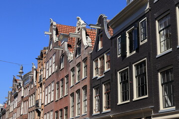 Fototapeta na wymiar Amsterdam Traditional Historic House Facades with Bell Gables Against a Blue Sky