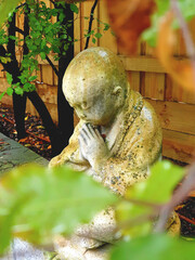 praying stone buddha in a garden
