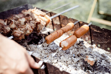Close up of kebabs on skewers, man grilling meat outdoors