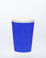 Photo of a disposable blue paper cup on a white background. Photo of a colored coffee cup made of recyclable materials. Empty paper coffee cup.