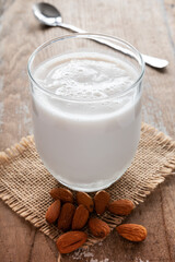 A glass of almond milk with almonds around