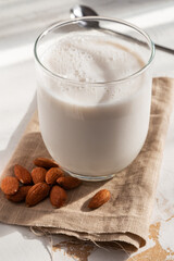 A glass of almond milk with almonds around