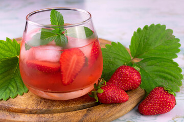 
Strawberry drink with ice and mint on a white background.
Close-up.