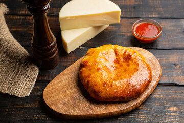 khachapuri with cheese on dark wooden background
