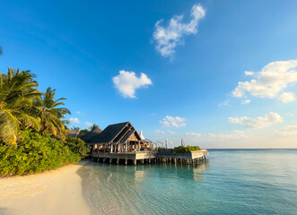 Obraz premium Amazing tropical Maldives island panorama. Beautiful beach and lagoon landscape background during sunrise. Vacation, holiday and romantic honeymoon banner concept.