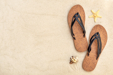 Flip flops with seashells on the sand. Copy space. Vacation and holiday background.