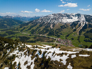 Aerial view on the village of Oberjoch in the Allgau Alps on a sunny day in May with last snow in...