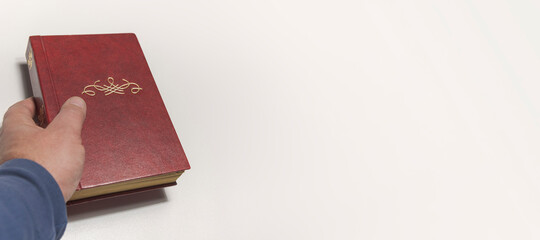 Old brown book in hand with monogram Free space for title. Banner of card on white background