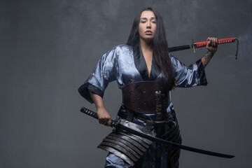 Oriental woman samurai with katanas in fog