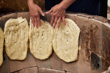 Women make bread by hand according to old recipes in an open oven. Handmade bread. Traditional Dagestan recipes