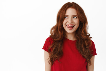 Portrait of happy pretty woman with red curly hairstyle, smiling thoughtful, lick lips from...