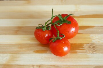 Top view of red organic tomatoes on wooden background.