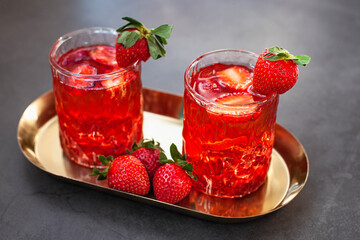 Red drink with ice and strawberry with leaves