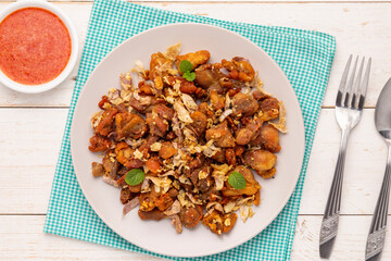 Flat lay crispy fried chicken with garlic and black pepper, served with hot and sour chili garlic dipping sauce, a simple Thai food dish going well with alcoholic drink, congee, or plain cooked rice. 