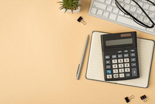 Top view photo of flowerpot glasses on keyboard calculator on grey copybook pen and binders on isolated beige background with copyspace