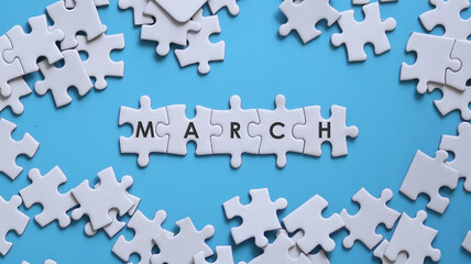 MARCH word written on white jigsaw puzzle