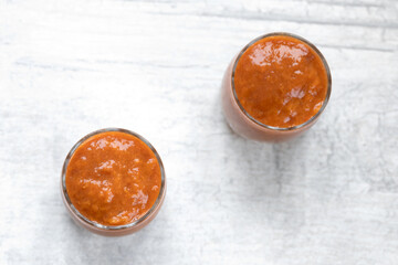 Apricot jam in two glass jars on the table. Selective focus.