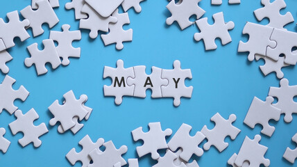 MAY word written on white jigsaw puzzle