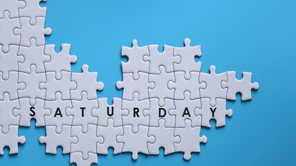 SATURDAY word written on white jigsaw puzzle