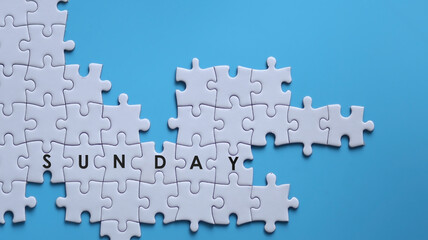 SUNDAY word written on white jigsaw puzzle
