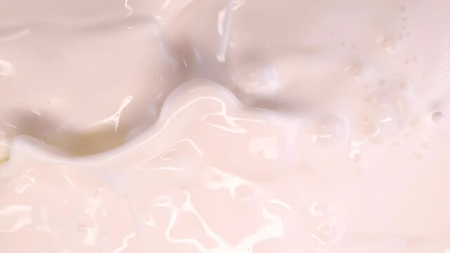 Mango splashing into cream, super slow motion footage. Mango cubes falls into milk. Concept: mango with milky cream or yoghourt, 