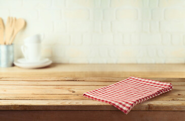 Empty wooden table with tablecloth over kitchen shelf background.  Interior mock up for design and...