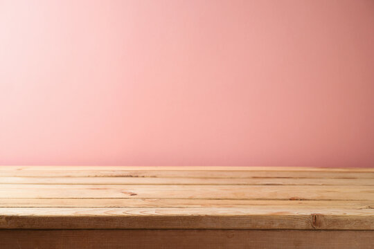 Empty wooden table over pink wall background. Interior mock up for design and product display.