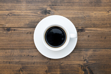 Top view of white coffee cup on wooden background