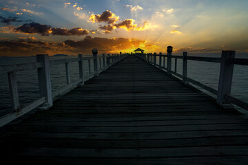 Wooden bridge in the sea sunrise landscape on background
