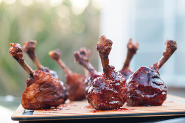 Glazed lolipops chicken legs on a gas grill 