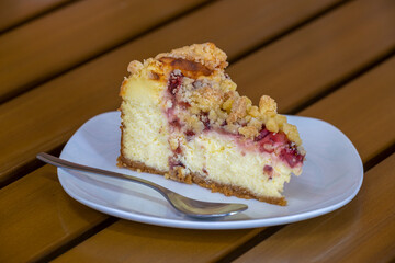 Slice of blueberry cheese cake on white plate