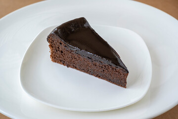 Slice of chocolate cake on white plate
