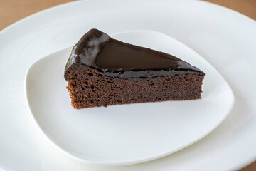 Slice of chocolate cake on white plate