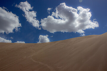 Fototapeta na wymiar sand dunes and clouds, Cloudy Day at the Sand Dunes, Tall Sand Dunes, Wall of Sand, Summer Day at the Sand Dunes