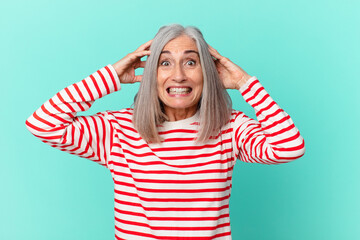 middle age white hair woman feeling stressed, anxious or scared, with hands on head