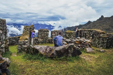 Photo sur Plexiglas Machu Picchu Back view of three male friends contemplating the majestic Phuyupatamarca ruins on Inca trail to Machu Picchu archaeological site from the Inca's ancient civilization in Peru. South America