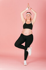 Young plus size woman practicing yoga