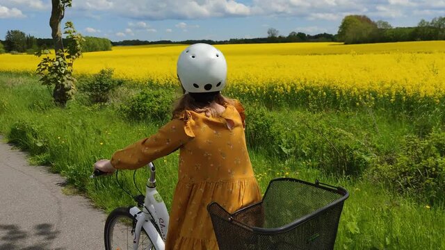 Probsteierhagen, Germany- May 25, 2021. Pretty teen girl ride white bicycle on country road