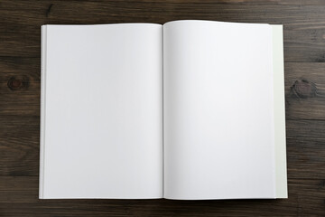 Open blank paper brochure on wooden table, top view. Mockup for design