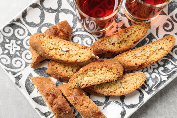Tray with tasty cantucci and glasses of liqueur on light table, top view. Traditional Italian almond biscuits