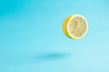 Flying lemon half on blue background.