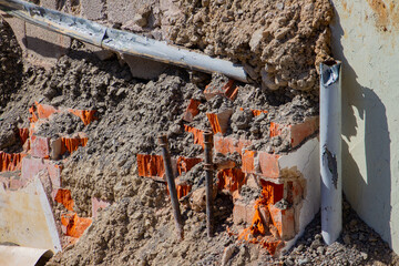 Pipes and damaged red bricks of a demolished building