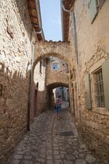 Fototapeta na wymiar Femme touriste montant une ruelle déserte du vieux village de Mirmande (Drôme)