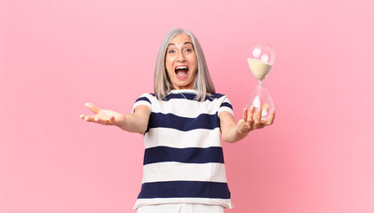 middle age white hair woman holding a sandglass timer