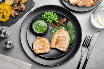 Grilled squid tubes served on grey table, flat lay