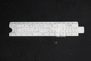 Logarithm ruler isolated on black background mechanical calculator isolated.