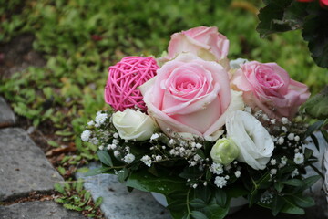 Arrangement von Rosen in Rosa und Weiß als Grabschmuck auf dem Friedhof
